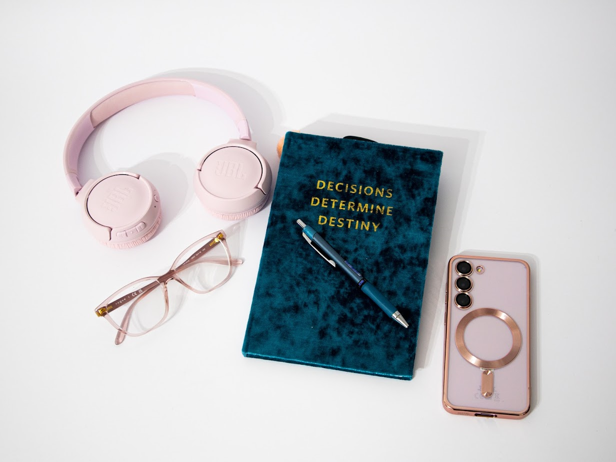 Photo of notebook, pink phone, pink headphones, pink glasses