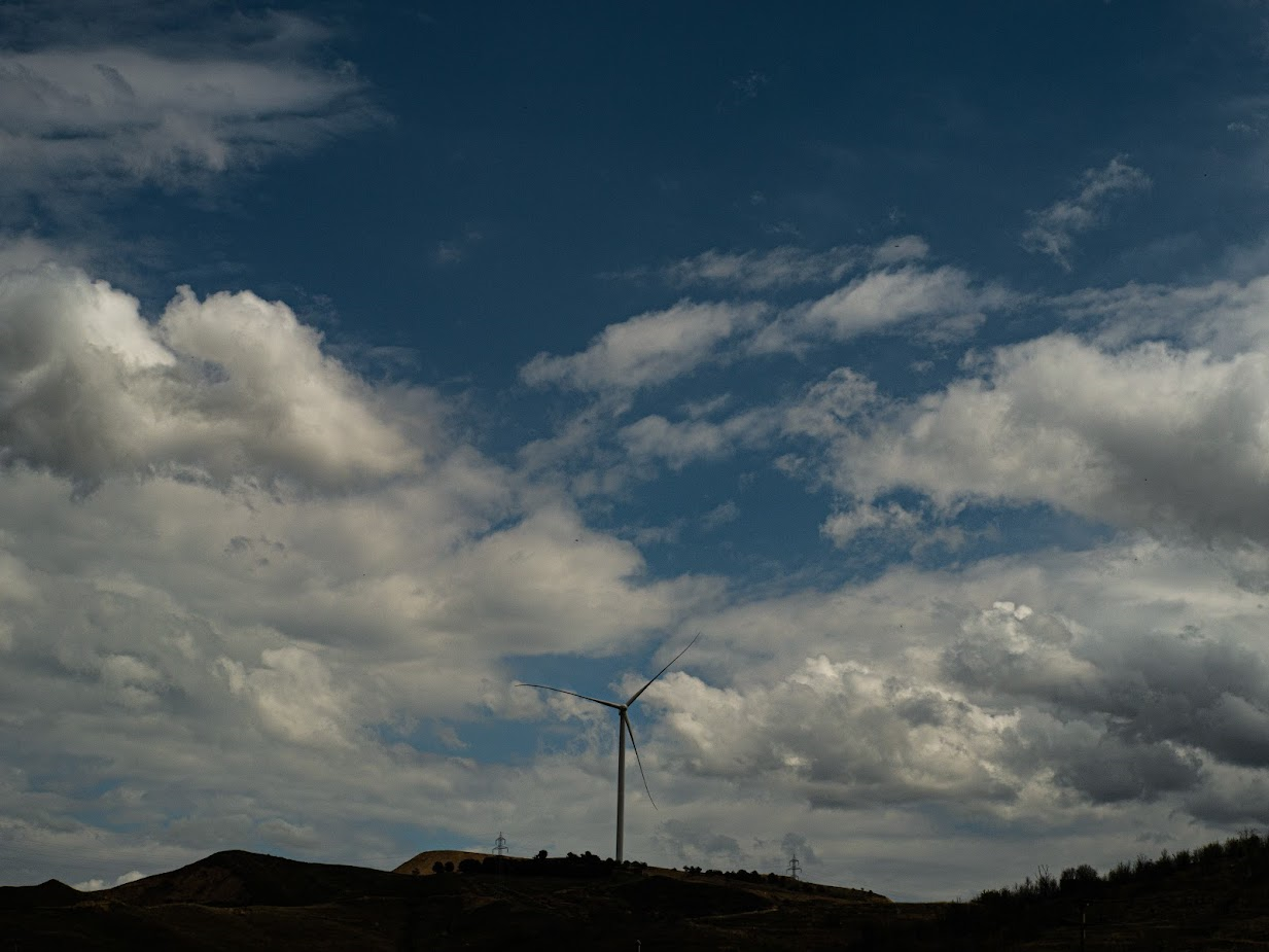 Photo of a windmill with cloudy sky in the background