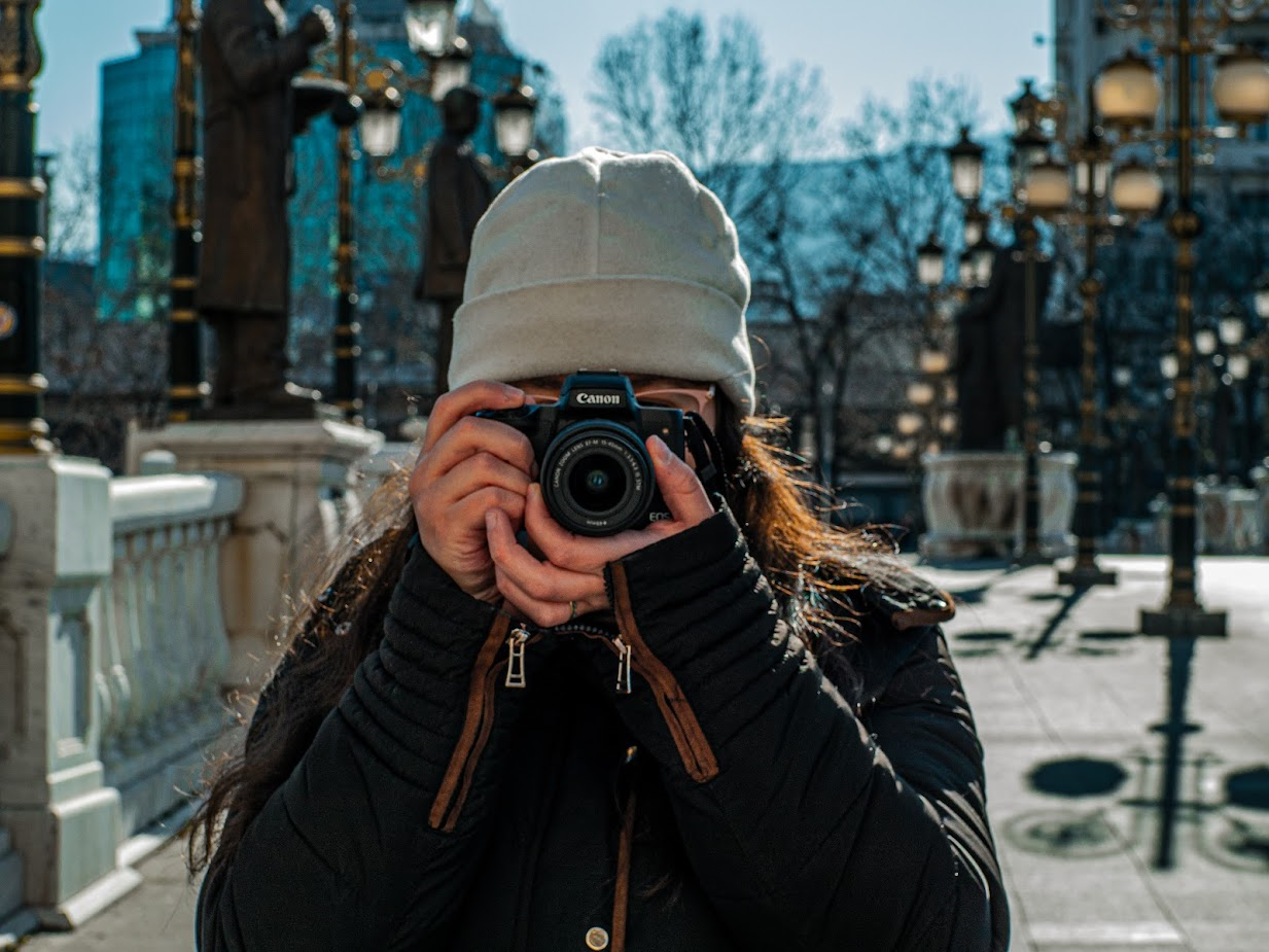 Photo of a woman hoding a camera